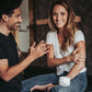 Man and woman smiling while using micro-oxygen body lotion on hands and elbows.